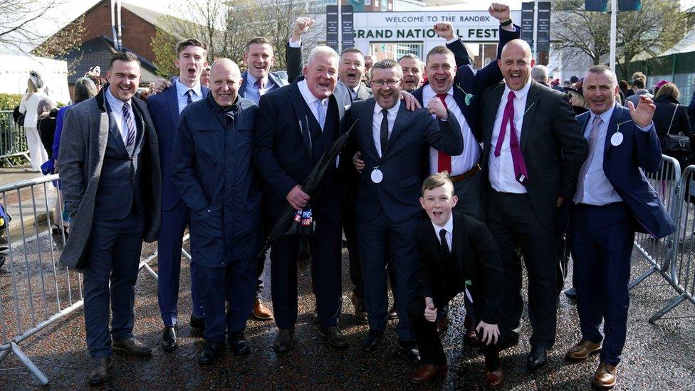 Group of men celebrating the return of crowds to the Grand National Festival