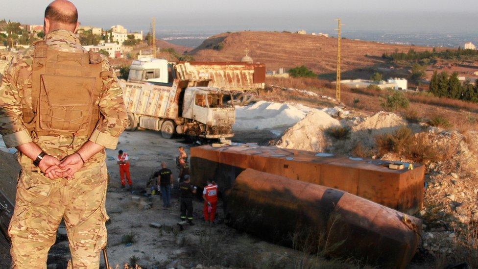 A Lebanese soldier stands guard at the scene of a petrol tank explosion in Akkar, Lebanon (15 August 2021)