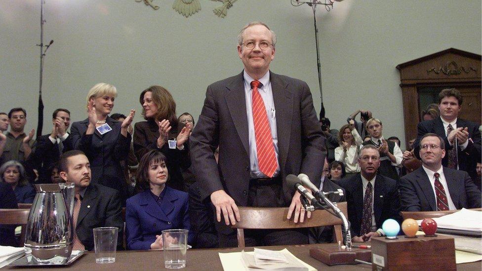 Independent Counsel Kenneth Starr stands as supporters applaud after he completed approximately twelve hours of testimony before the House Judiciary Committee on Impeachment Inquiry 19 November, 1998 on Capitol Hill in Washington DC