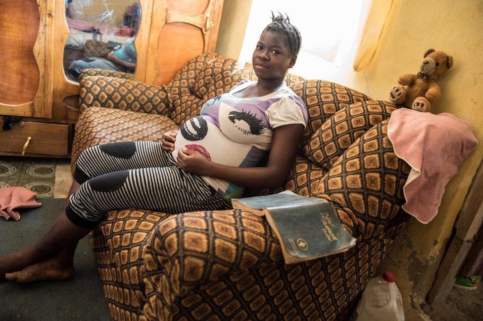 Isha sits on the sofa