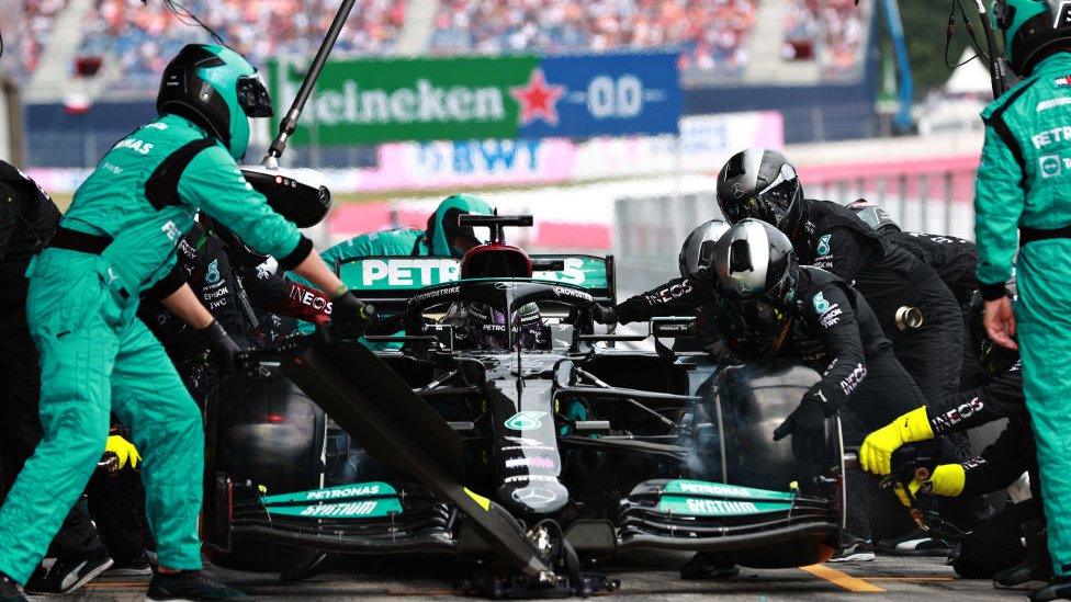 Lewis Hamilton in his car with his team