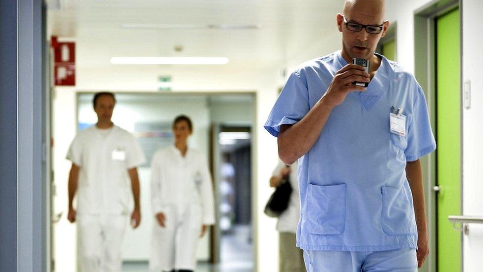 Doctor walking while dictating notes in GP surgery