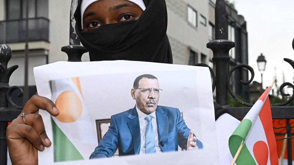 A supporter holds an image of Mr Bazoum during a rally in Niamey