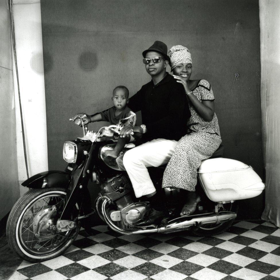 A family on a motorbike in a photo studio in Mali