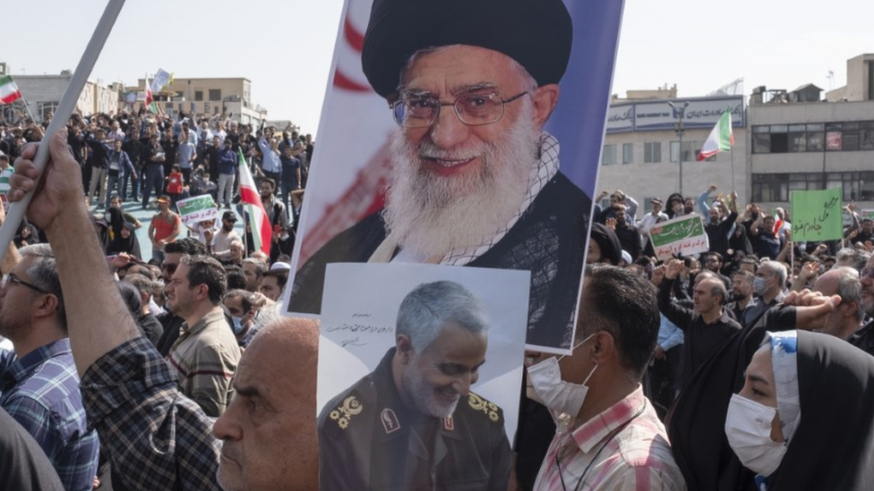 Pro-government demonstrators hold aloft a portrait of the supreme leader