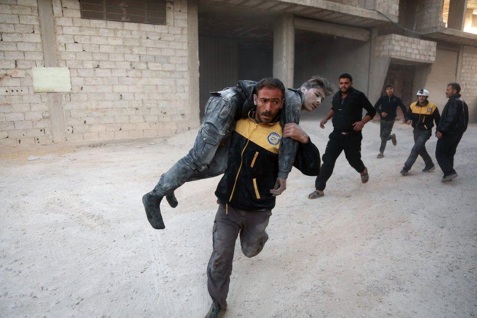 White helmets rescue an injured fighter in a Damascus suburb in 2017