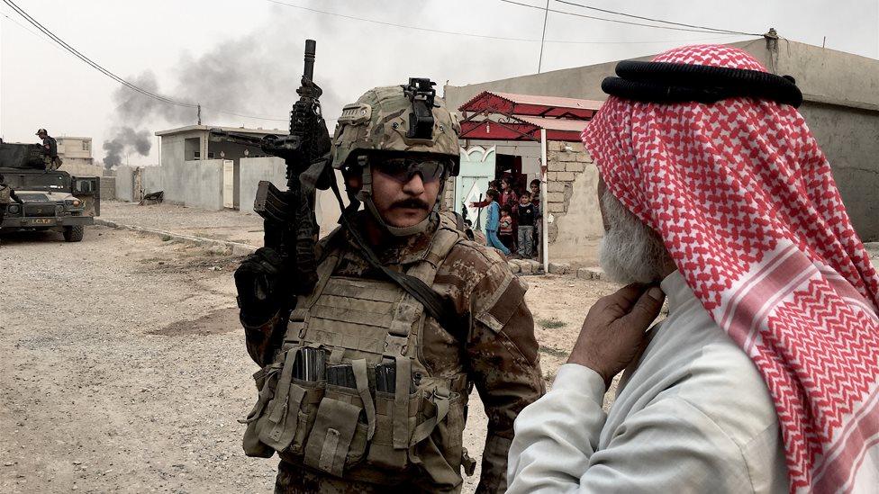 A member of the Iraqi special forces speaks to a civilian in Kukjali