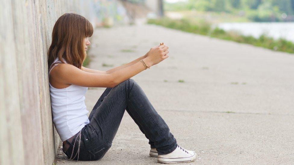 Girl sitting alone outside