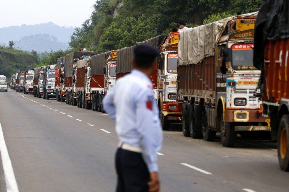 A policeman looks at trucks stranded on the Jammu-Srinagar highway in Nagrota, near Jammu, on August 9, 2019,