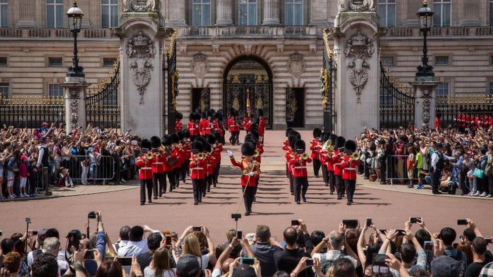 Tourists watching the changing of the guard outside Buckingham Palace