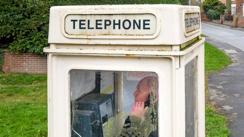 Image of a man using one of the protected phone boxes