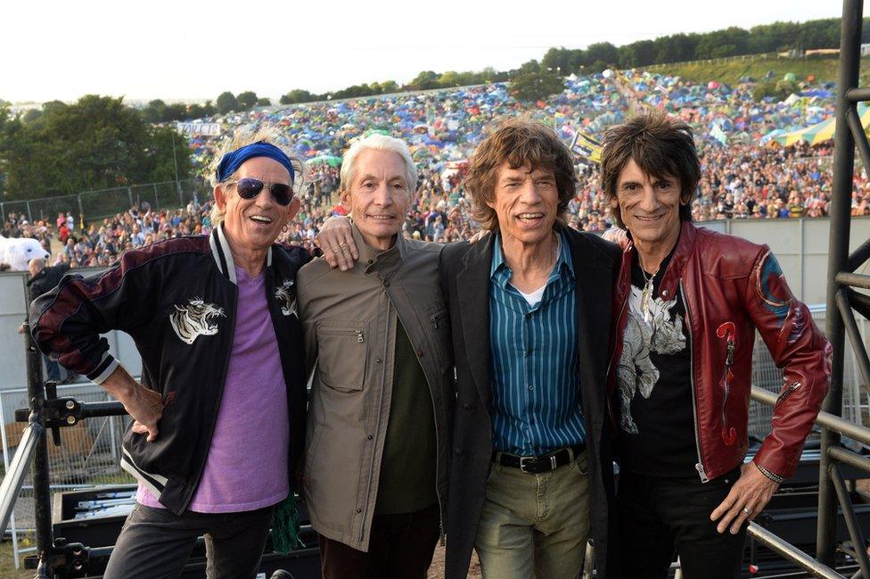 The Rolling Stones pose for a portrait in front of crowds