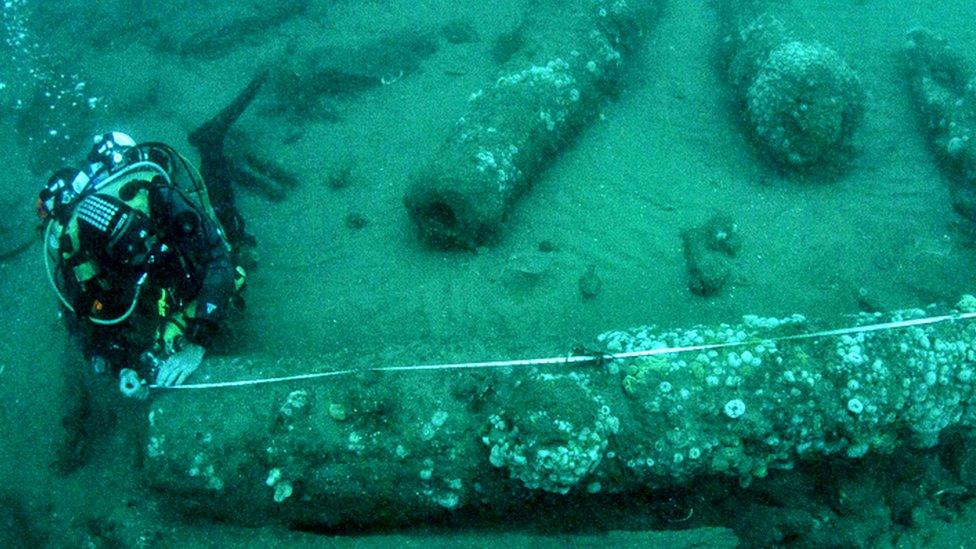 The brothers measuring a cannon underwater