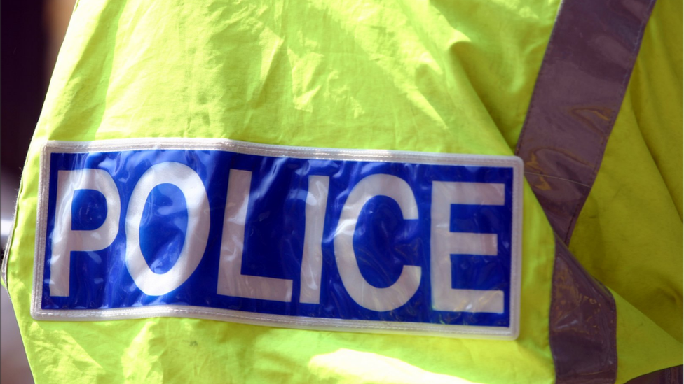 Back of a policeman wearing a fluorescent jacket