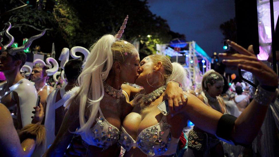 A female couple in silver bikinis, one with a unicorn horn, kiss during the annual Sydney Gay and Lesbian Mardi Gras festival in Sydney, Australia March 4, 2017.