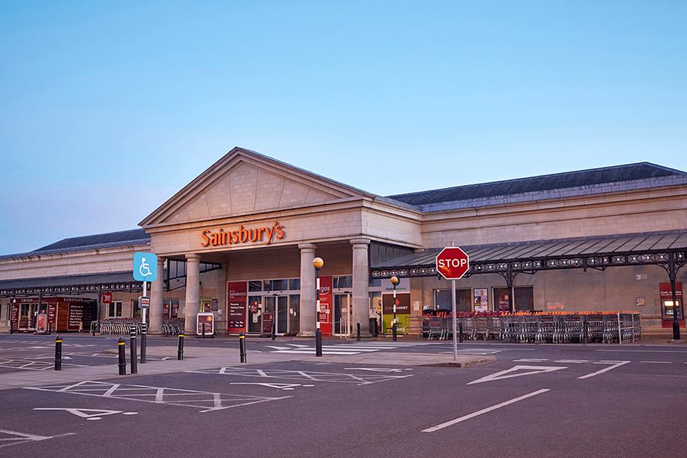 A view of the front of a Sainsbury's supermarket and an empty car park