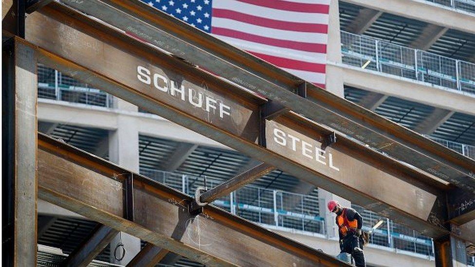 Contractor walks on a steel beam