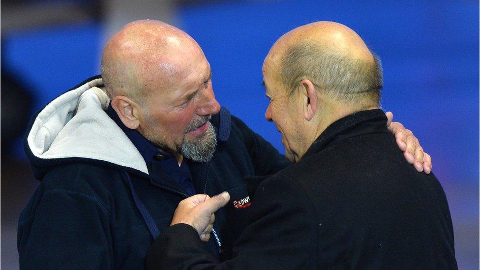 French Defence Minister Jean-Yves Le Drian (R) embraces Serge Lazarevic (L), France's last remaining hostage after landing at the Villacoublay military base near Paris, France on December 10, 2014.