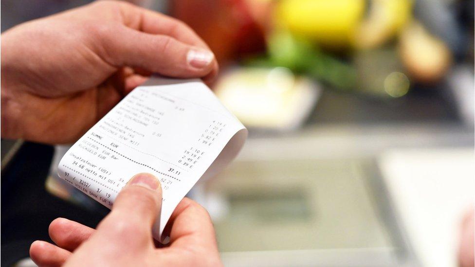 Photo of a woman looking at a receipt