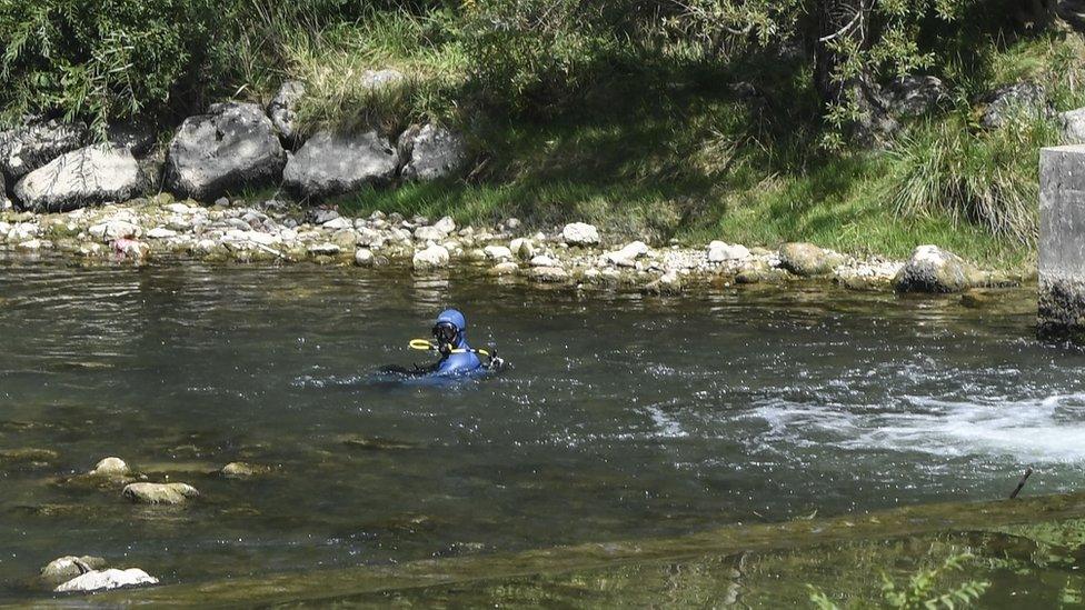 A diver of the French gendarmerie searches the Guiers river in Pont-de-Beauvoisin, eastern France, on Tuesday after Maëlys, a nine-year-old girl, disappeared during a wedding party in the early hours of Sunday