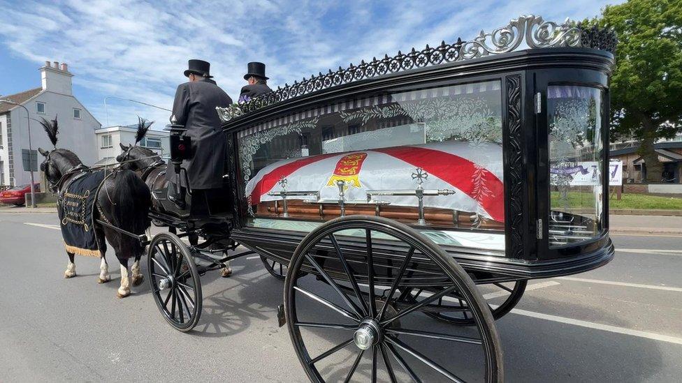 horse and carriage carrying coffin