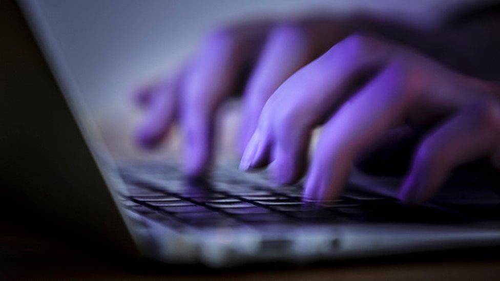 A woman typing on a keyboard