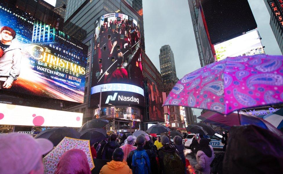 Spectators in Times Square watch the video