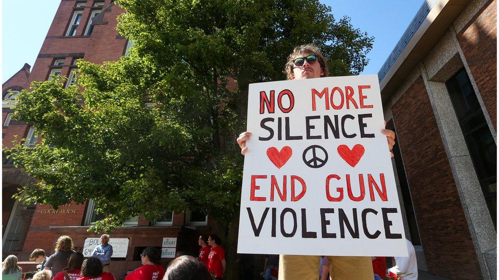 Protesters holding signs against gun violence