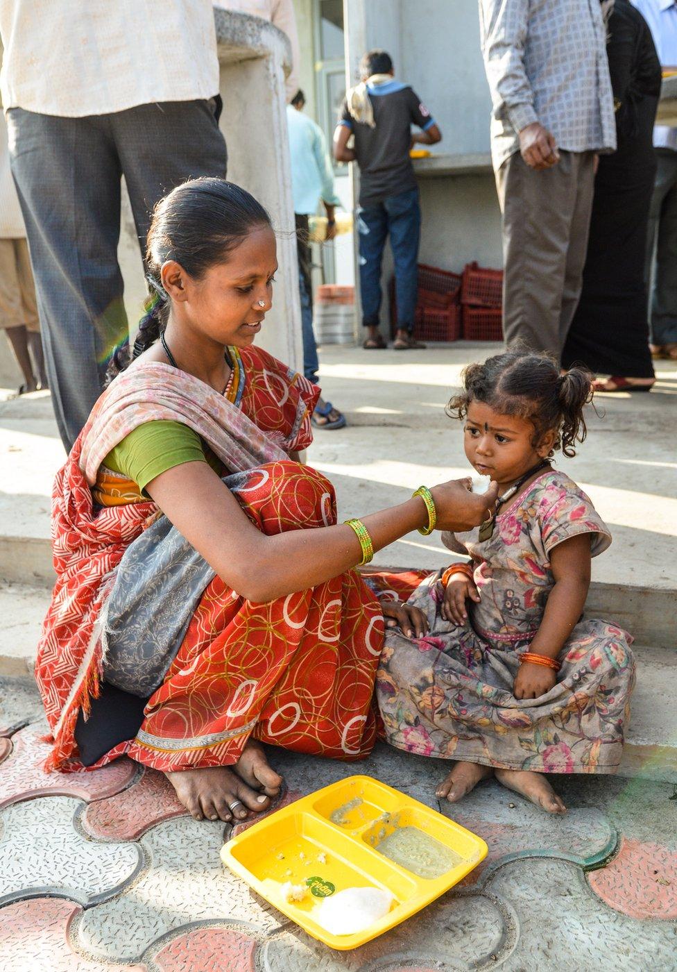 A mother feeds her baby