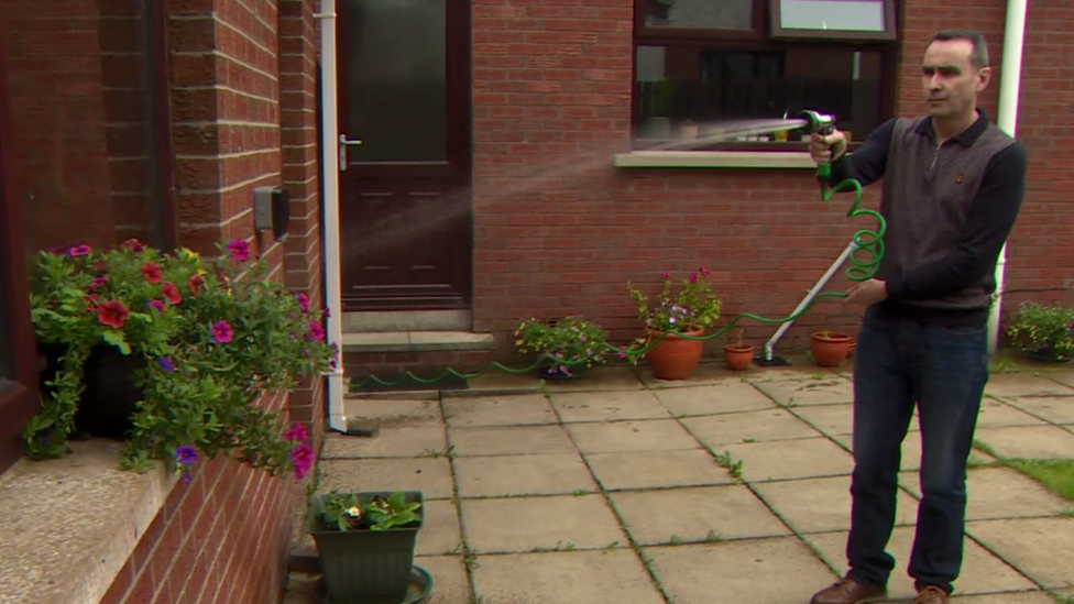 A man, Jim Balmer, watering his plants