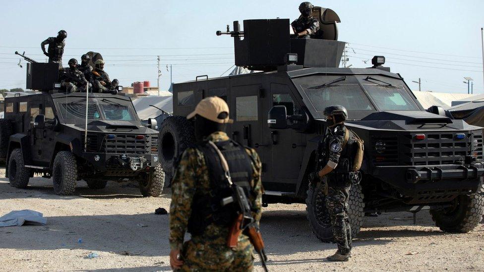 File photo showing a Syrian Democratic Forces (SDF) fighter stands near Kurdish internal security special forces during a security operation in al-Hol camp, in north-east Syria (26 August 2022)