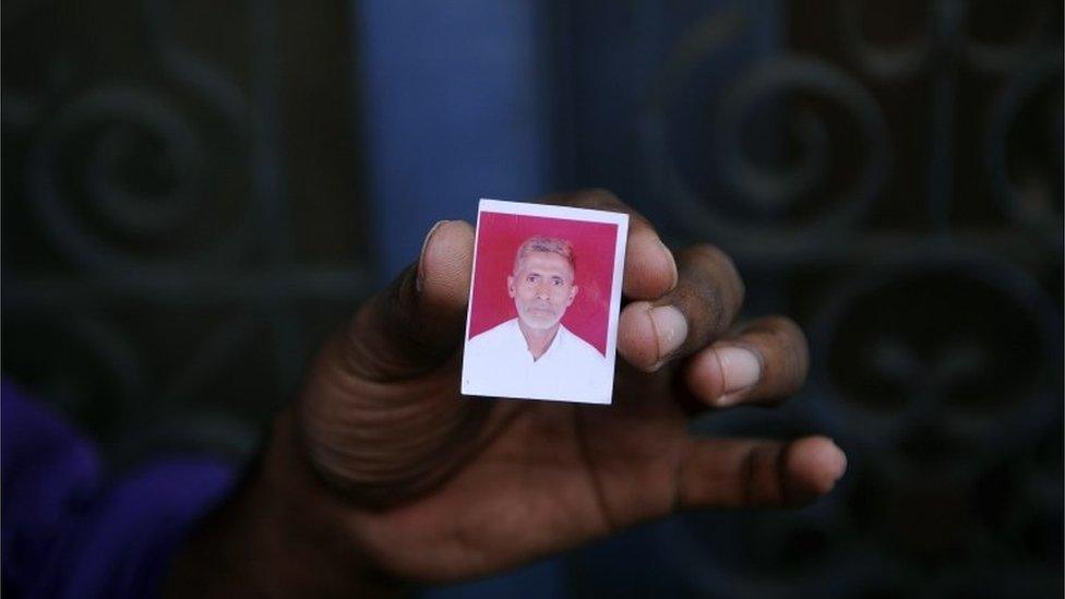 A relative holds a photograph of slain Indian villager Mohammad Akhlaq at his home in the village of Bisada,