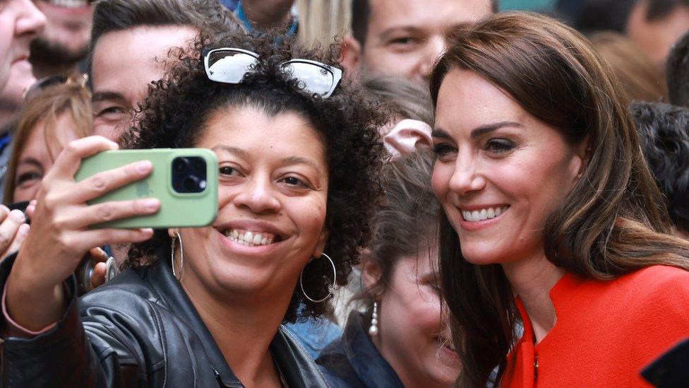 Catherine, Princess of Wales smiles and takes pictures with well wishers during visit to the Dog & Duck Pub to speak to members of staff to hear how it's preparing for the Coronation Weekend during her visit to Soho on May 04, 2023