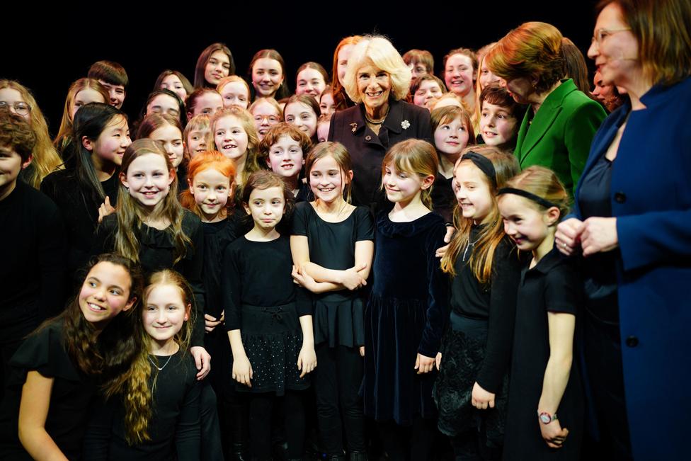 The Queen Consort and First Lady Elke Budenbender (green jacket) pose for a photo with a group of school children following their perfomance at the Komische Opera Berlin, during day two the King and Queen's State Visit to Germany