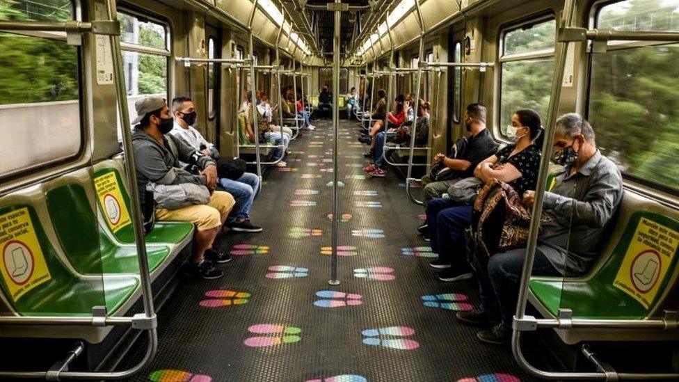 Commuters wear face masks and keep social distance as preventive measures against the spread of the COVID-19 coronavirus, on the metro in Medellin, Colombia, on June 17, 2020