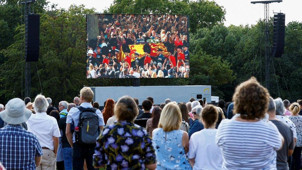 People watch a screen on the day the coffin of Britain's Queen Elizabeth is transported from Buckingham Palace to the Houses of Parliament for her lying in state