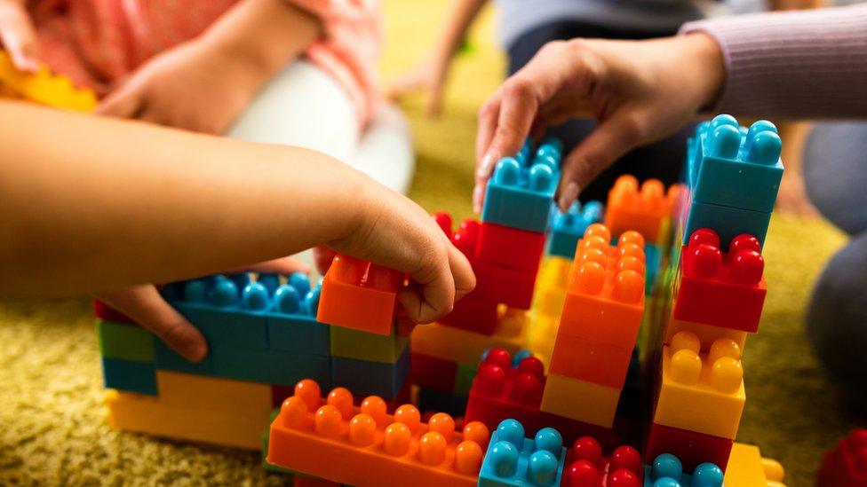 Preschool children playing with toy bricks