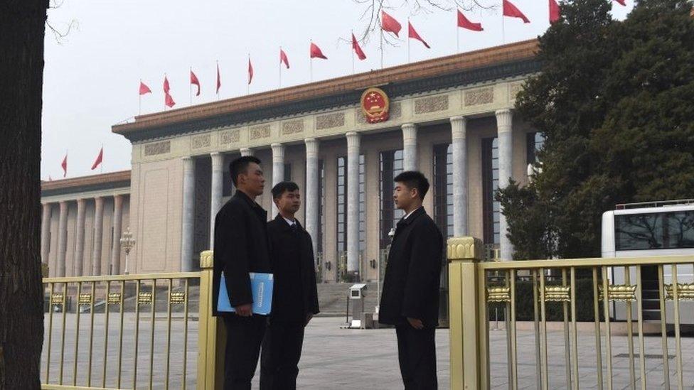 Security guards outside the Great Hall of the People in Beijing where meetings of the National People's Congress are being held (15 March 2016)