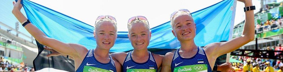 Liina, Lily and Leila Luik posing with the Estonian flag after finishing the marathon