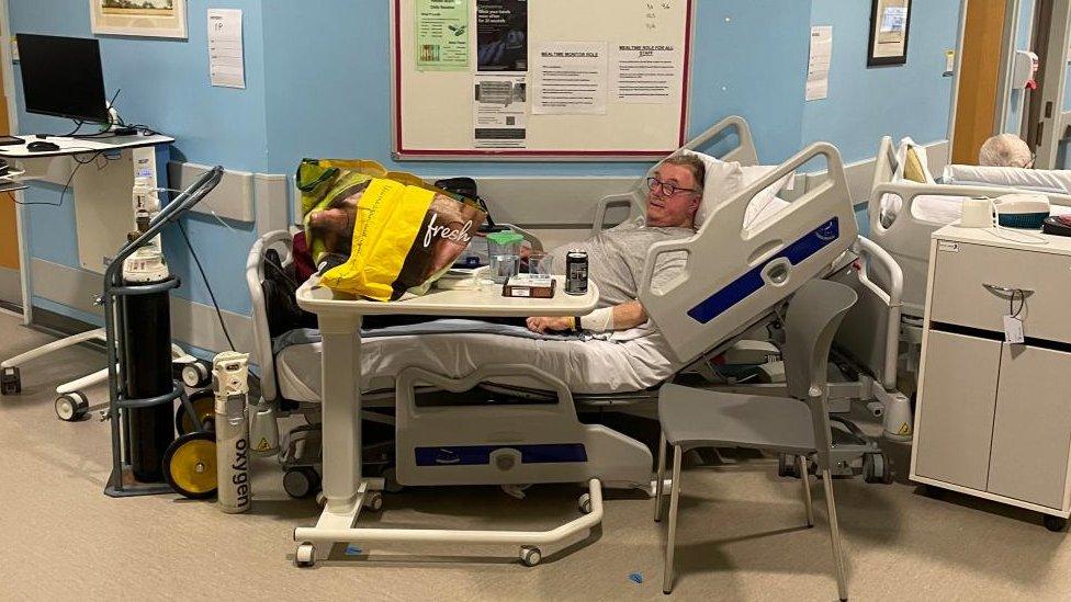 Ivan Philpotts in a hospital bed in a corridor at the Norfolk and Norwich University Hospital