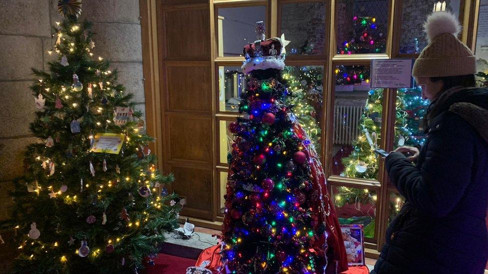 Someone stands by a Christmas tree
