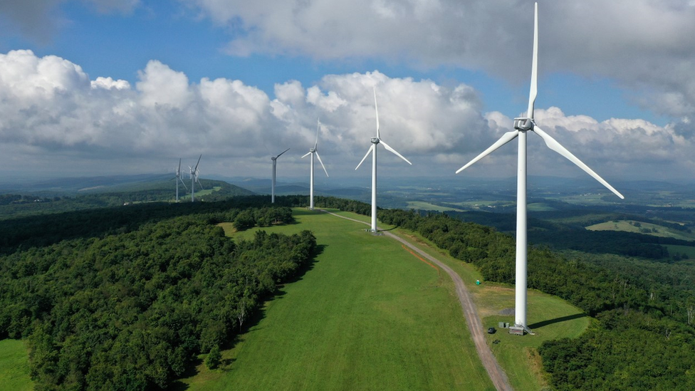 A row of wind turbines on the ridge of a hill