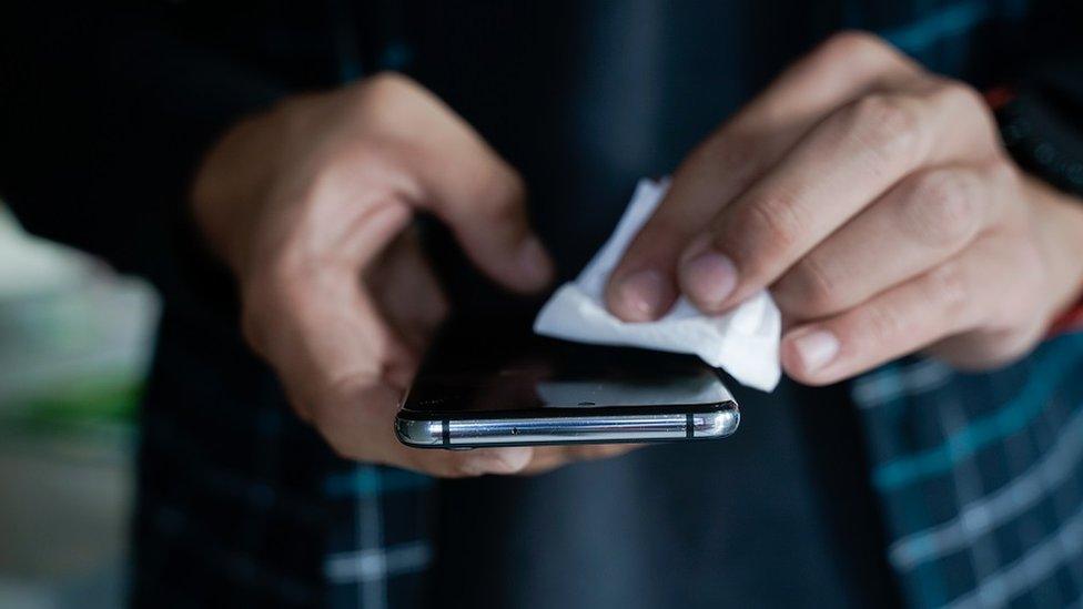 wiping smartphone screen - stock photo