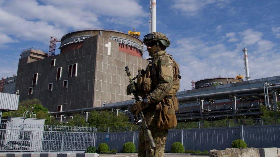 A Russian soldier stands guard outside Zaporizhzhia nuclear power plant