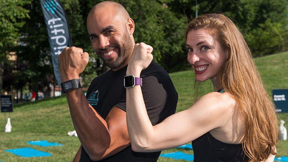 Man and woman wearing Fitbits