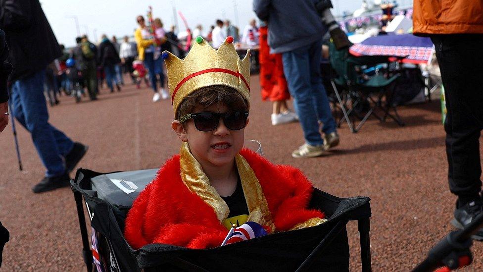 A young boy is pulled along by his dad as he arrives at the Big Lunch on the prom