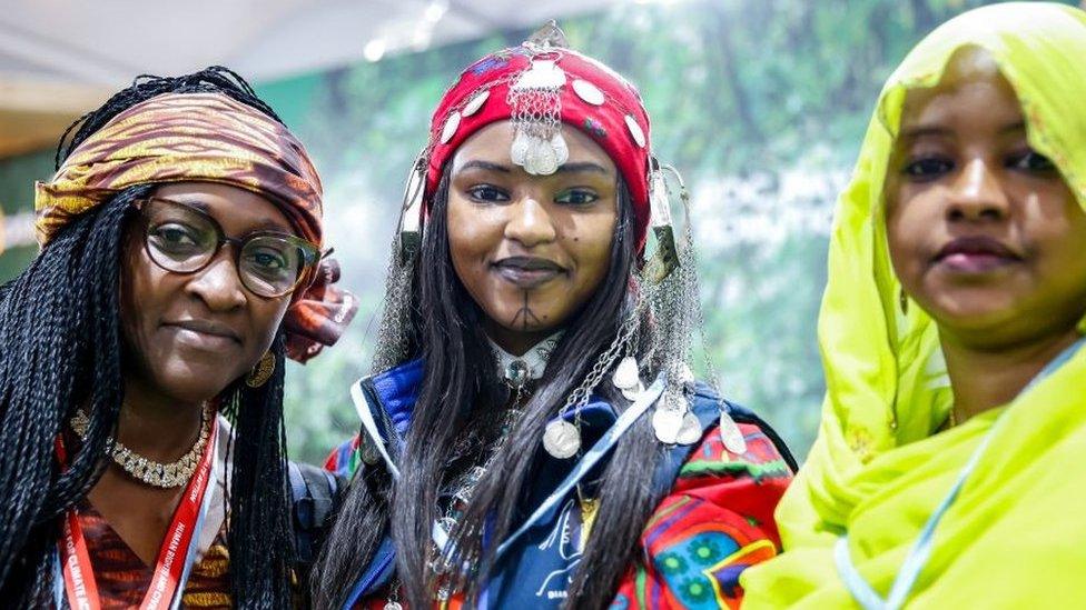 Women in traditional dresses pose in Congo Pavilion on the second day of the COP27 UN Climate Change Conference