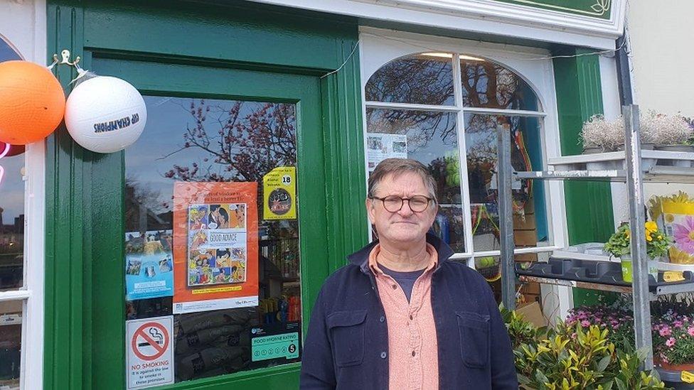 Kevin Og, in front of his newsagents in Strangford