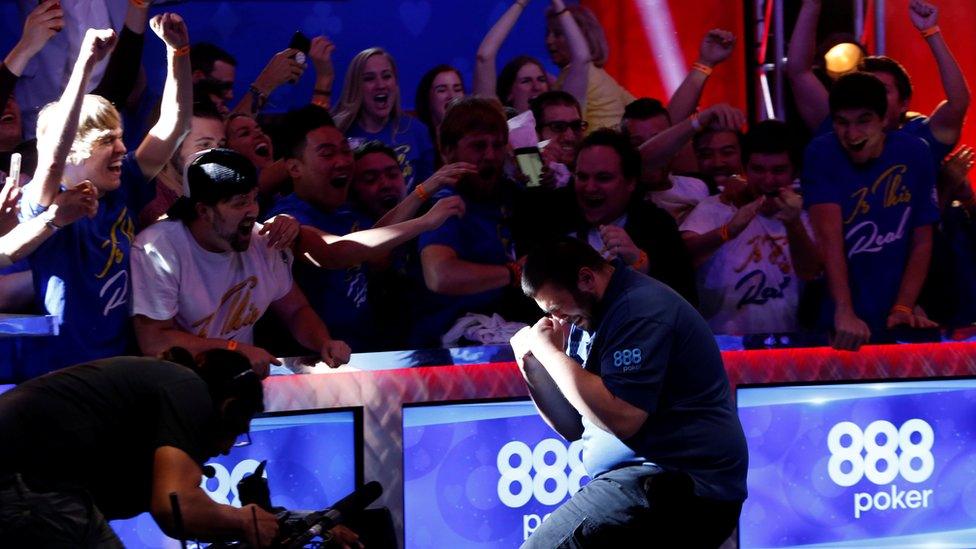 man laugh-crying in front of cheering crowd