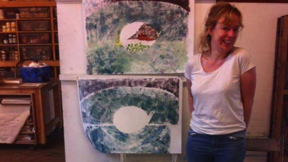 Jen Coles standing next to her own artwork